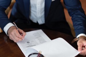 Ein Anwalt oder Steuerberater unterzeichnet ein wichtiges Dokument wie zum Beispiel ein Testament