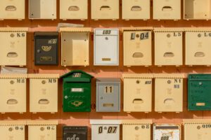 Colorful mailboxes arranged on a brick wall, showcasing vintage postal charm.