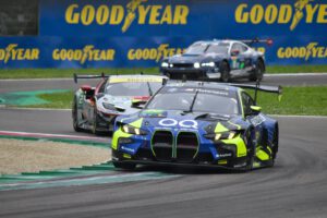 Dynamic action shot of racing cars competing on the track under Goodyear branding.