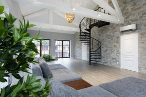 Interior of large prestige flat with soft gray sofa and verdant plants in daytime
